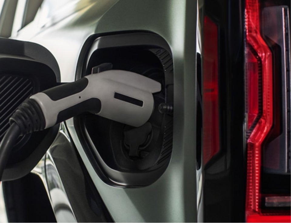Close up of charging port with charger plugged in on a GMC Hummer EV SUV - Les Stanford Buick GMC in FERNDALE MI