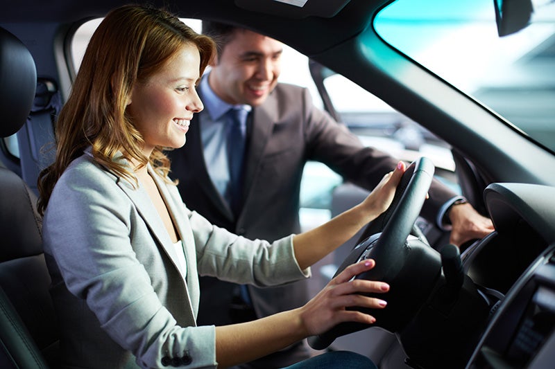 Woman test driving a vehicle in a dealership